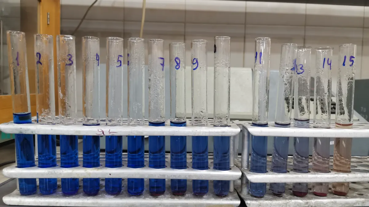 Rack of test tubes holding a graded series of blue standard solutions in a chemistry laboratory