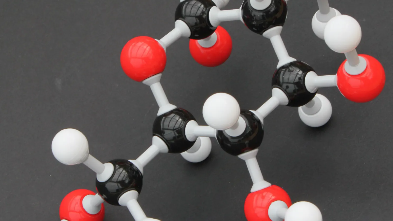 Ball-and-stick molecular model on a grey background, representing the structural chemistry behind PT-141 research